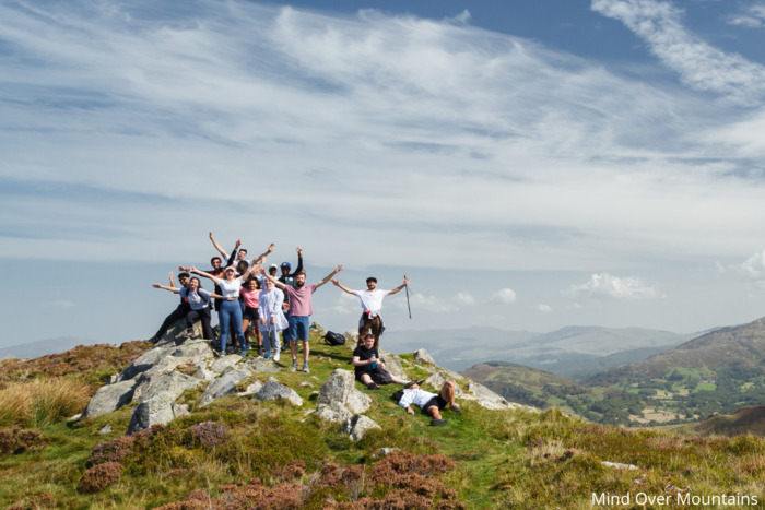 A group of hikers celebrating at the top of a charity walk for Mind Over Mountains