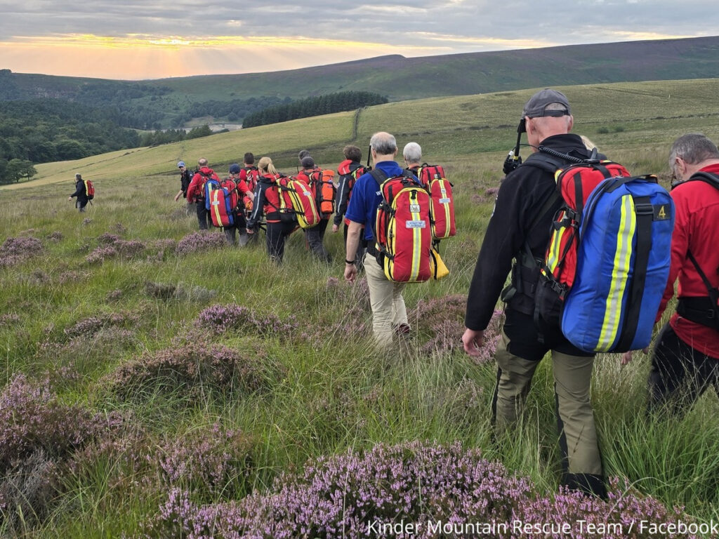 Kinder Mountain Rescue Team walking through long grass